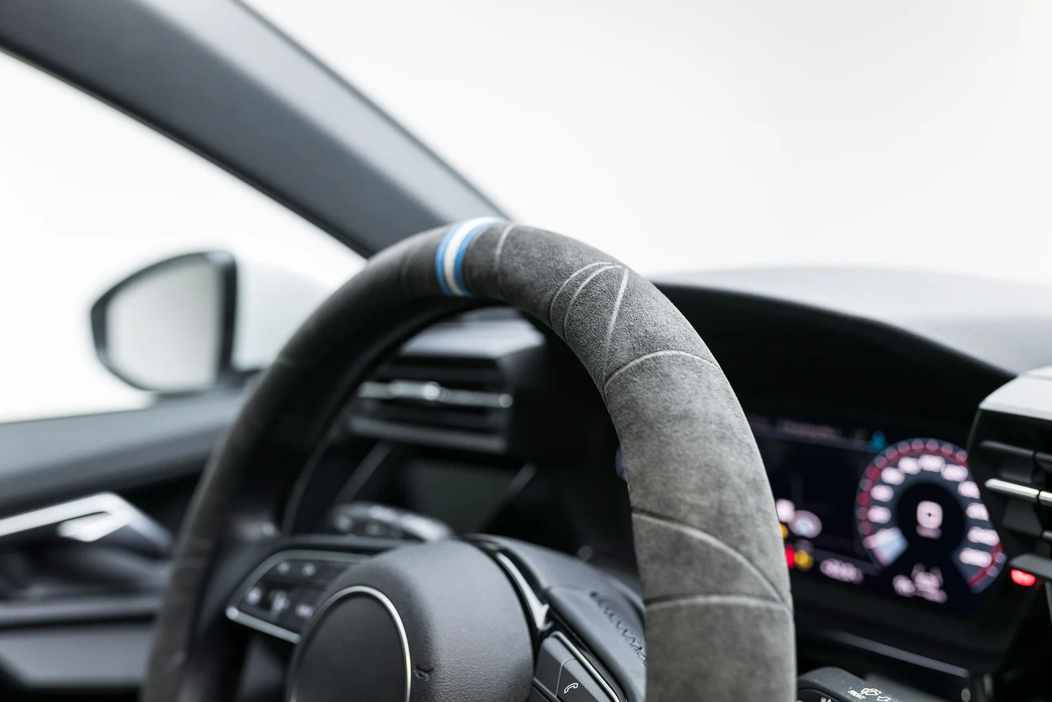 Detailaufnahme eines S-Tetic Lenkradbezugs aus dunklem Alcantara